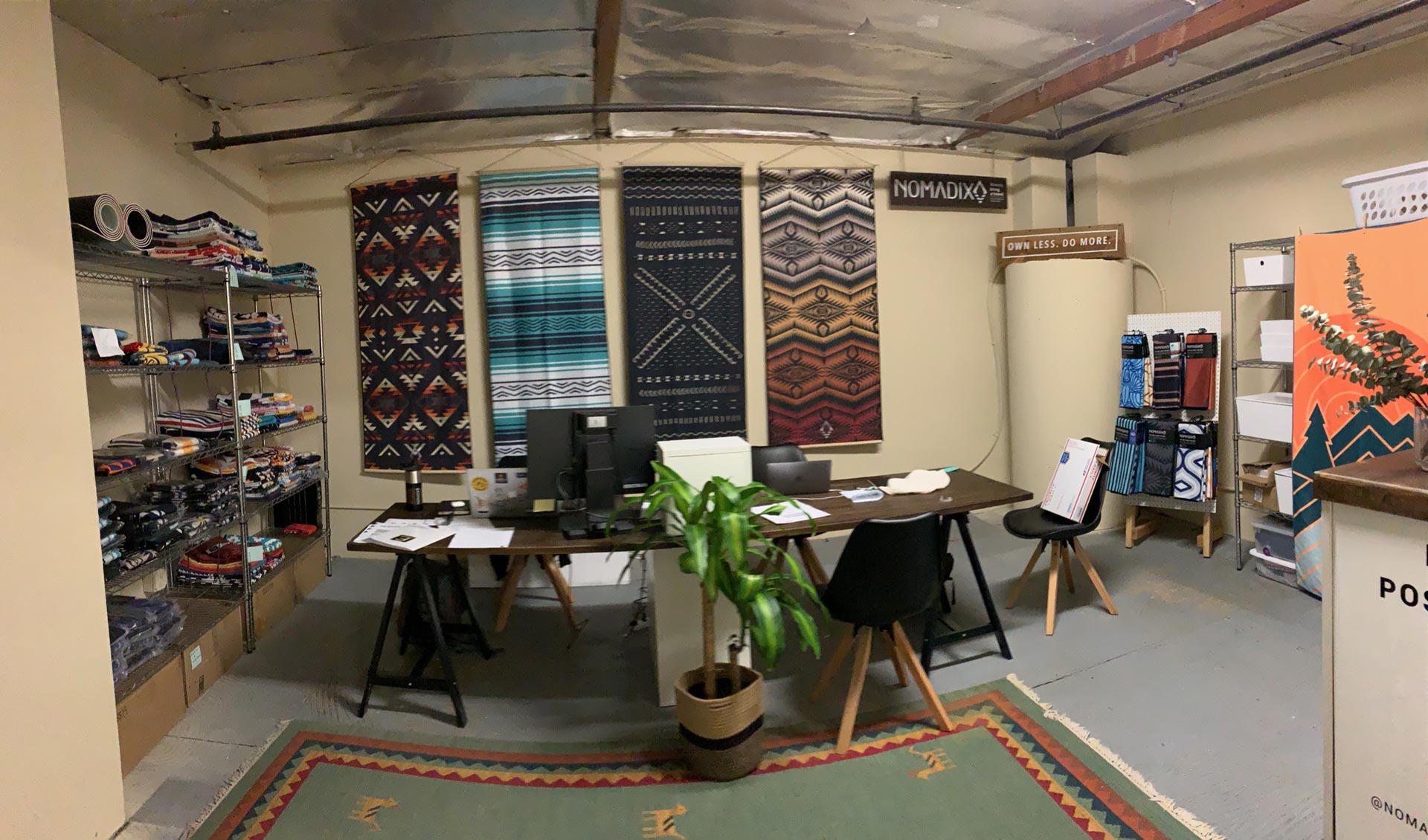 Nomadix showroom displays patterned towels on walls and shelves around office desks