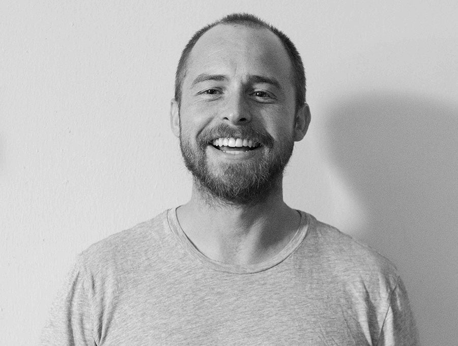 Black-and-white portrait of Nomadix co-founder Chace Petersen smiling in a gray T-shirt