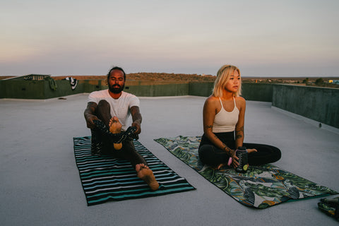 Two people on yoga mat towels.