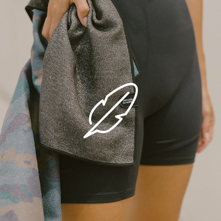 A person stands with the underside of a Nomadix towel.