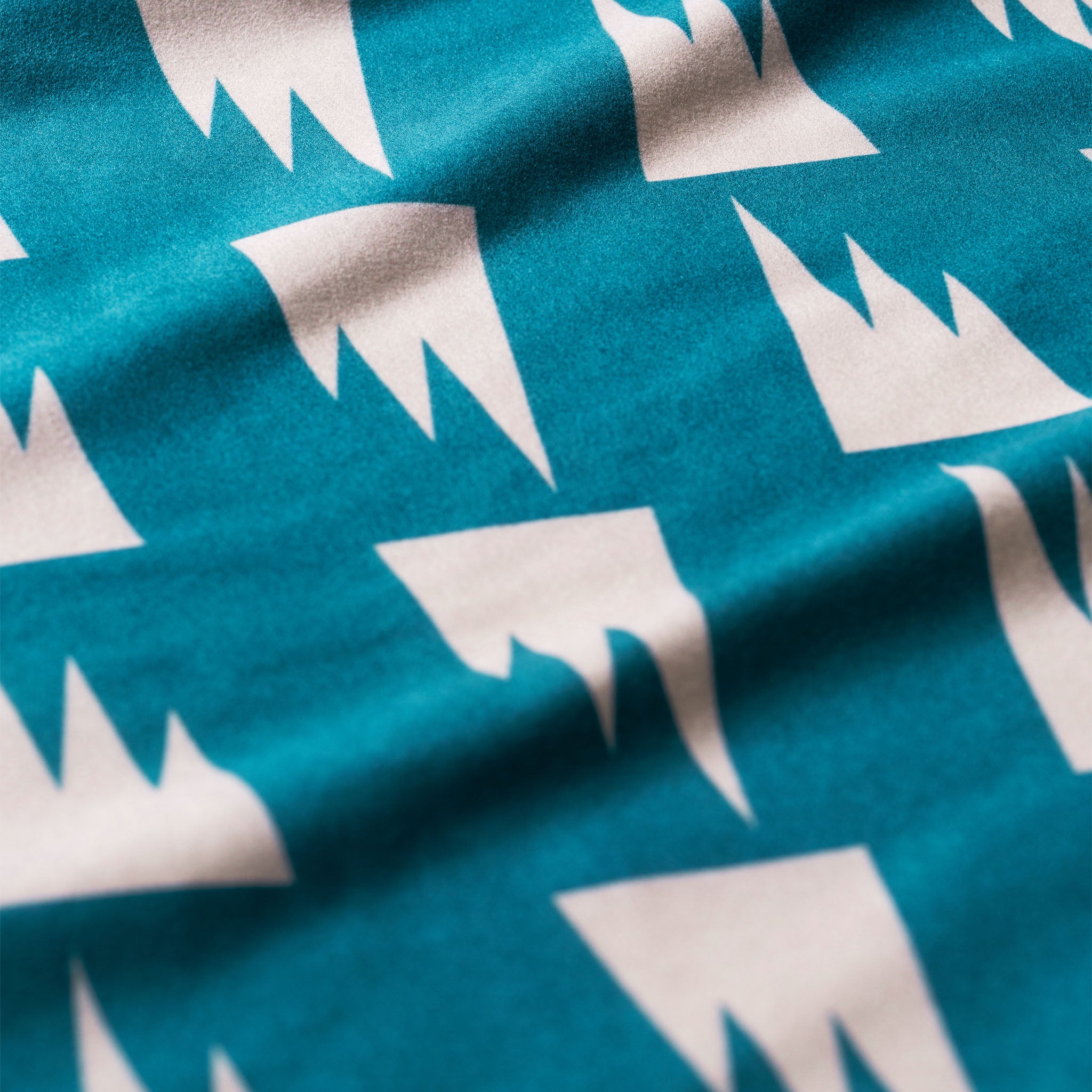 Close-up of Summit Green Ultralight Towel showcasing a cream geometric pattern and textured fabric